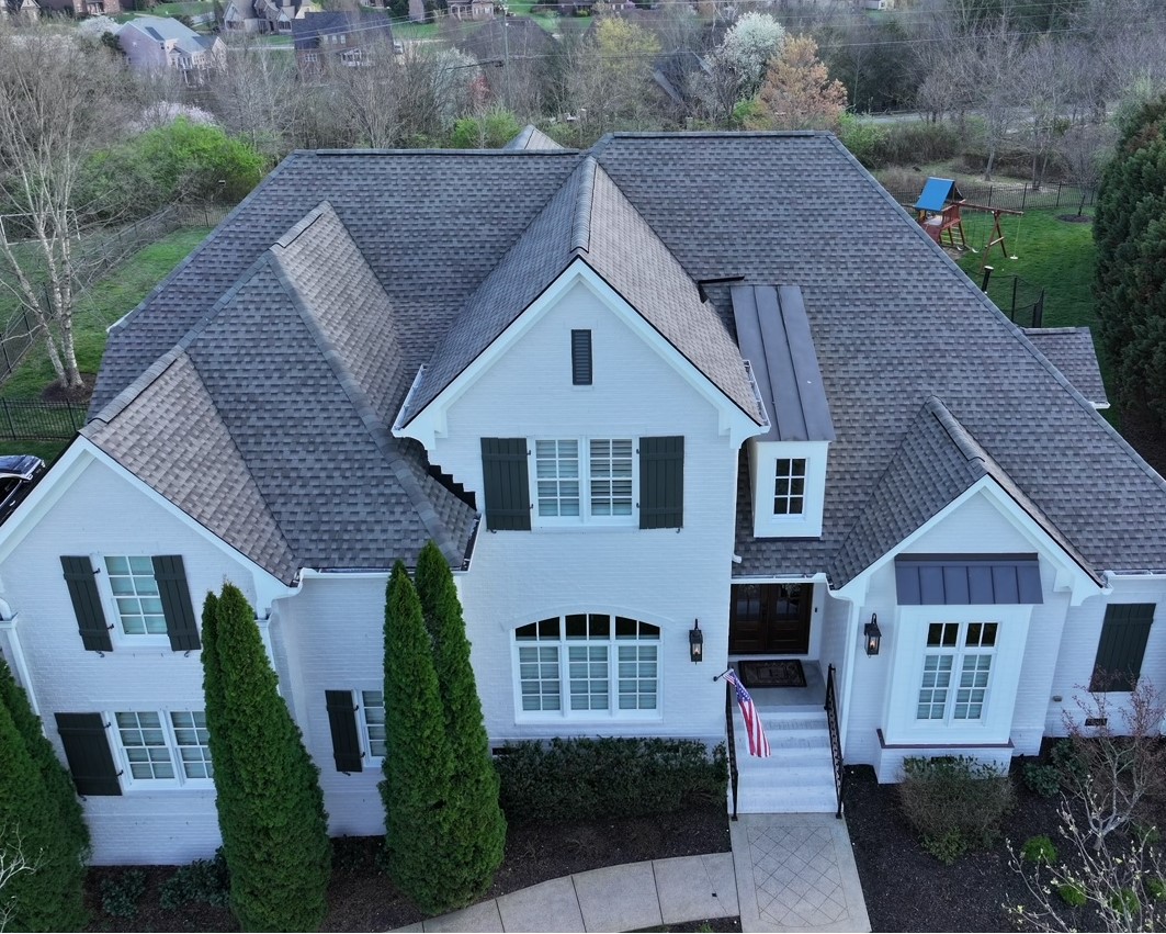 Aerial view of white residential home and gray roofing