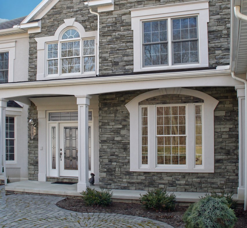 Front view of brick residential home with white bordered wh=indows